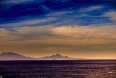 Scenic view of sea against dramatic sky during sunset