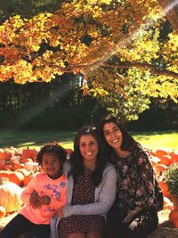 Portrait of smiling young woman in park during autumn