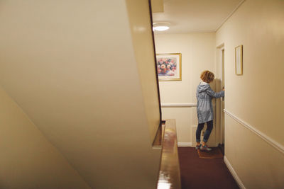 Rear view of woman standing in staircase