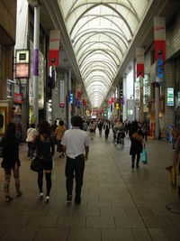 People walking in illuminated corridor in city