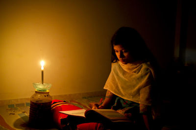 Girl looking away while sitting on table