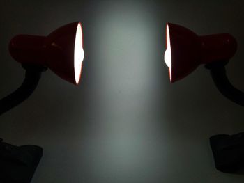 Low angle view of illuminated electric lamp on wall