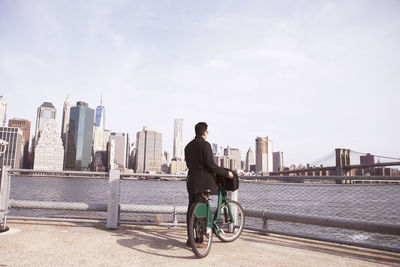 Businessman with bicycle enjoying city view from observation point