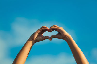 Low angle view of heart shape against blue sky