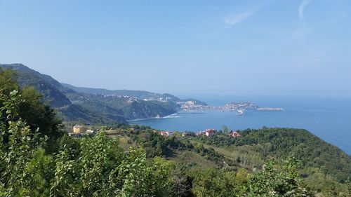 Scenic view of sea and mountains against clear sky