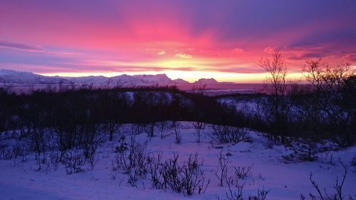 Scenic view of snowcapped landscape against romantic sky at sunset