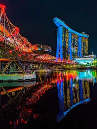 Illuminated bridge over river at night