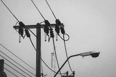 Low angle view of electricity pylon against clear sky