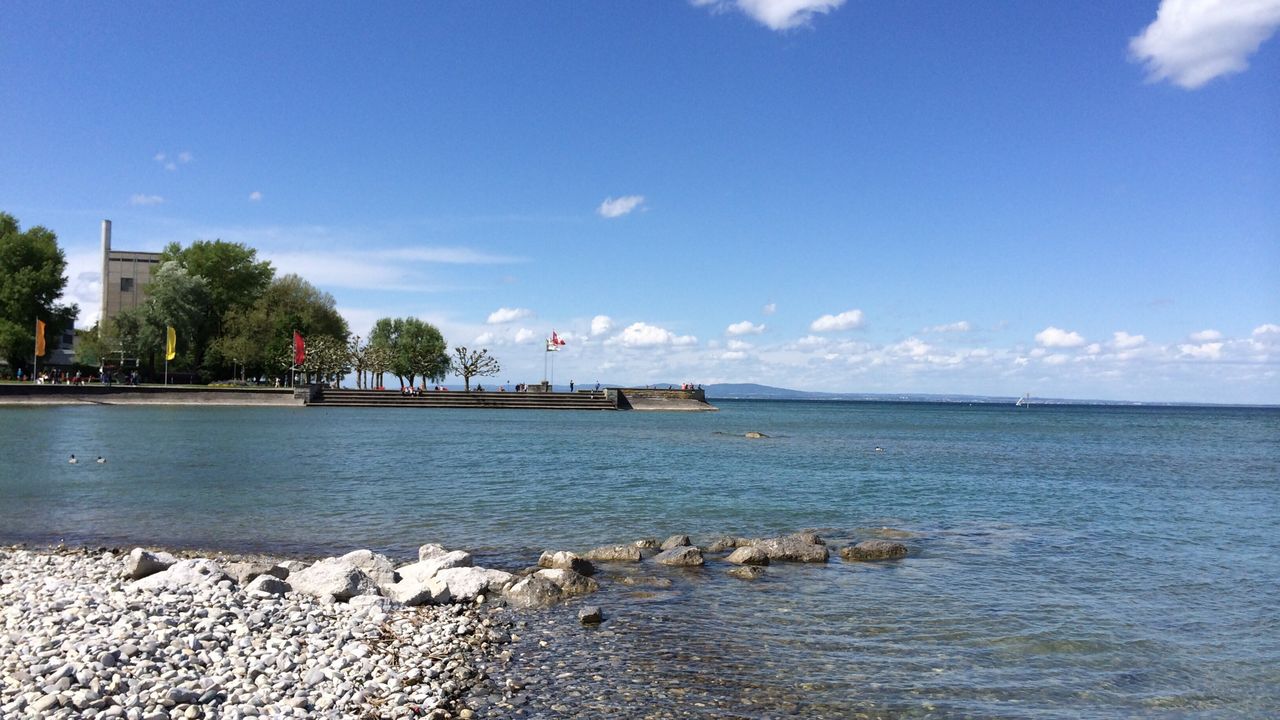 water, sky, sea, blue, tranquil scene, tranquility, beach, scenics, tree, cloud - sky, cloud, beauty in nature, horizon over water, nature, waterfront, shore, rippled, built structure, idyllic, day