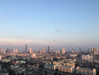 Aerial view of buildings in city against sky