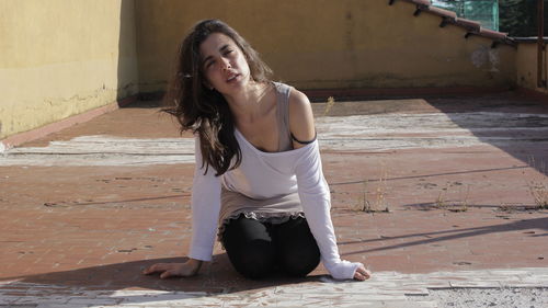 Portrait of smiling young woman sitting on floor