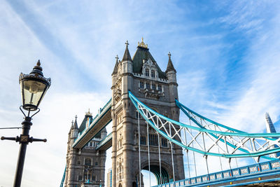 Low angle view of bridge against cloudy sky