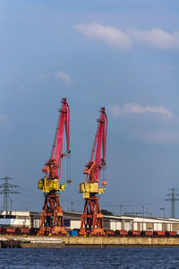 Cranes at construction site against sky