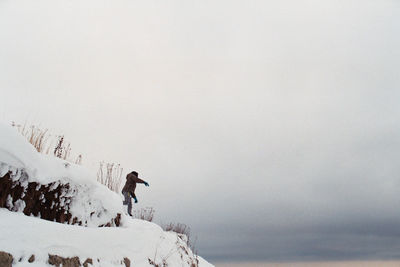 Man standing in snow against clear sky