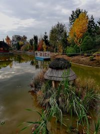 Gazebo by lake against sky during autumn