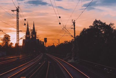 Railroad tracks against sky during sunset