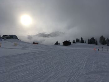 Panoramic view of people on snow covered mountain against sky