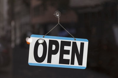 Close-up of information sign hanging on glass