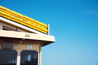 Low angle view of yellow building against blue sky