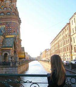 Rear view of a woman with buildings in background