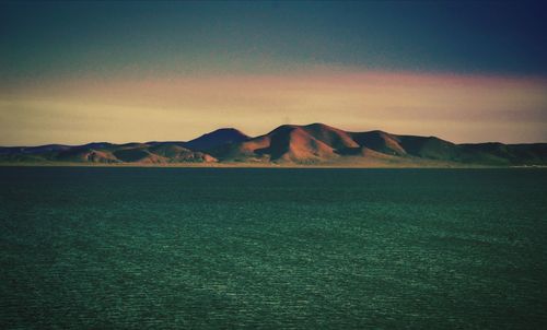 Scenic view of sea and mountains against sky