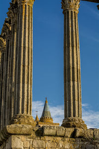 Low angle view of architectural columns against blue sky