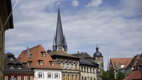 Buildings in city against cloudy sky