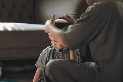 Midsection of man wearing skull cap to son