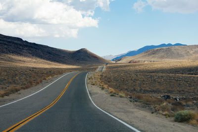 Empty road leading towards mountains