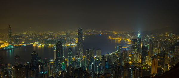 Illuminated cityscape against sky at night