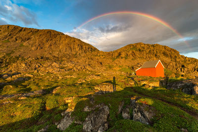 Scenic view of rainbow over mountain against sky