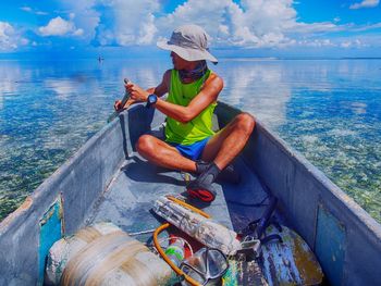 Full length of man sailing on boat in sea against sky