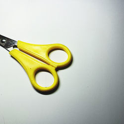 Close-up of yellow paint on table against white background