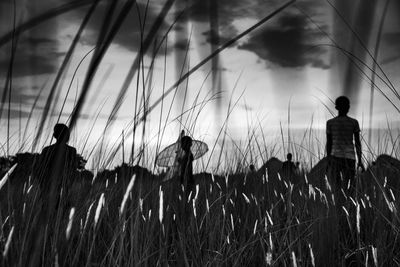 Rear view of silhouette man standing on field against sky