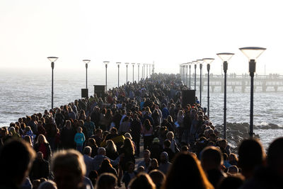 Group of people on sea shore against sky