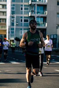 Full length of man running on street in city
