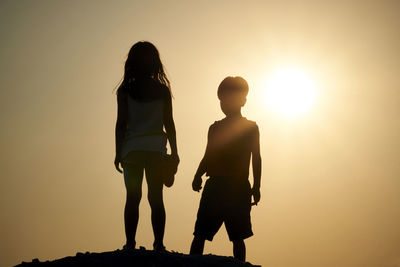 Silhouette people standing against clear sky during sunset