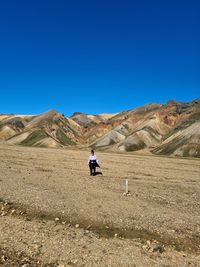 Rear view of man riding motorcycle on mountain