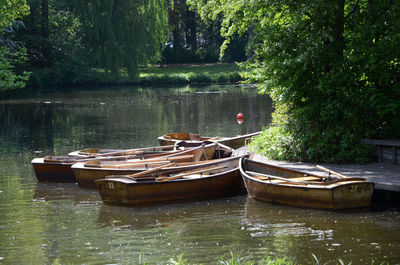 Boats moored in lake against trees