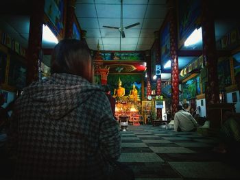 Rear view of people sitting on street at night