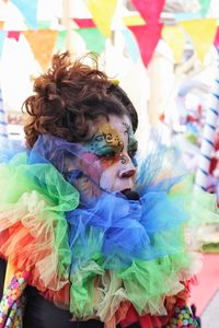 Mid adult woman in face paint looking away while standing outdoors