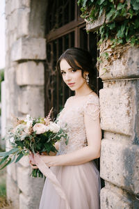 Young woman standing against wall