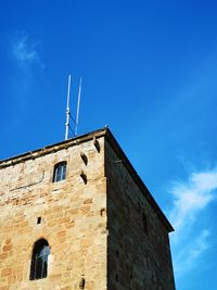 Low angle view of old building against blue sky