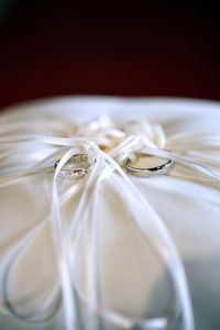 Close-up of wedding rings on pillow. 