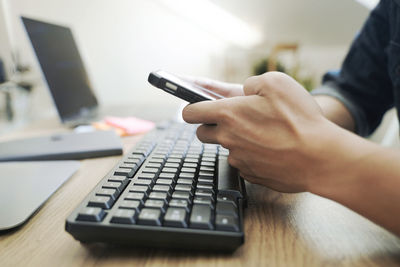Midsection of man using laptop on table