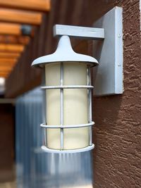 Close-up of electric lamp on table against building