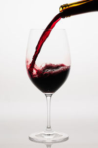 Close-up of wineglass against white background