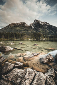 Scenic view of lake by mountains against sky