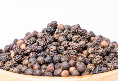 Close-up of black pepper against white background