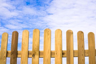 Low angle view of wooden posts against sky